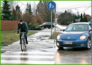 jedzie na rowerze po drodze dla pieszych