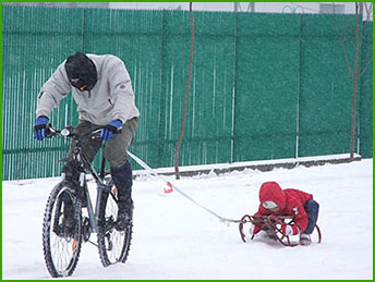 rowerzysta ciągnie sanki