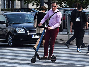 jedzie na hulajnodze po przejściu