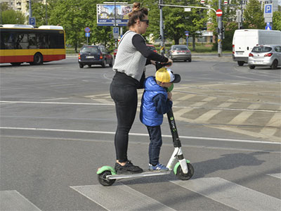 jedzie na hulajnodze po przejściu