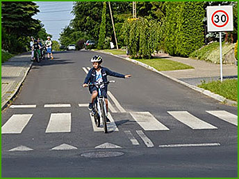 rowerzysta skręca w lewo na jezdni dwukierunkowej