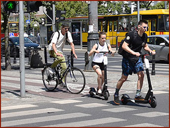 jedzie hulajnogą na przejeździe rowerowym